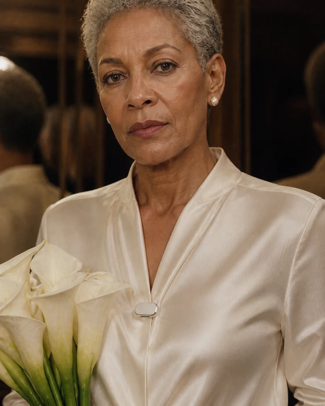 Ivory Presence Key worn on a white blouse beside calla lilies