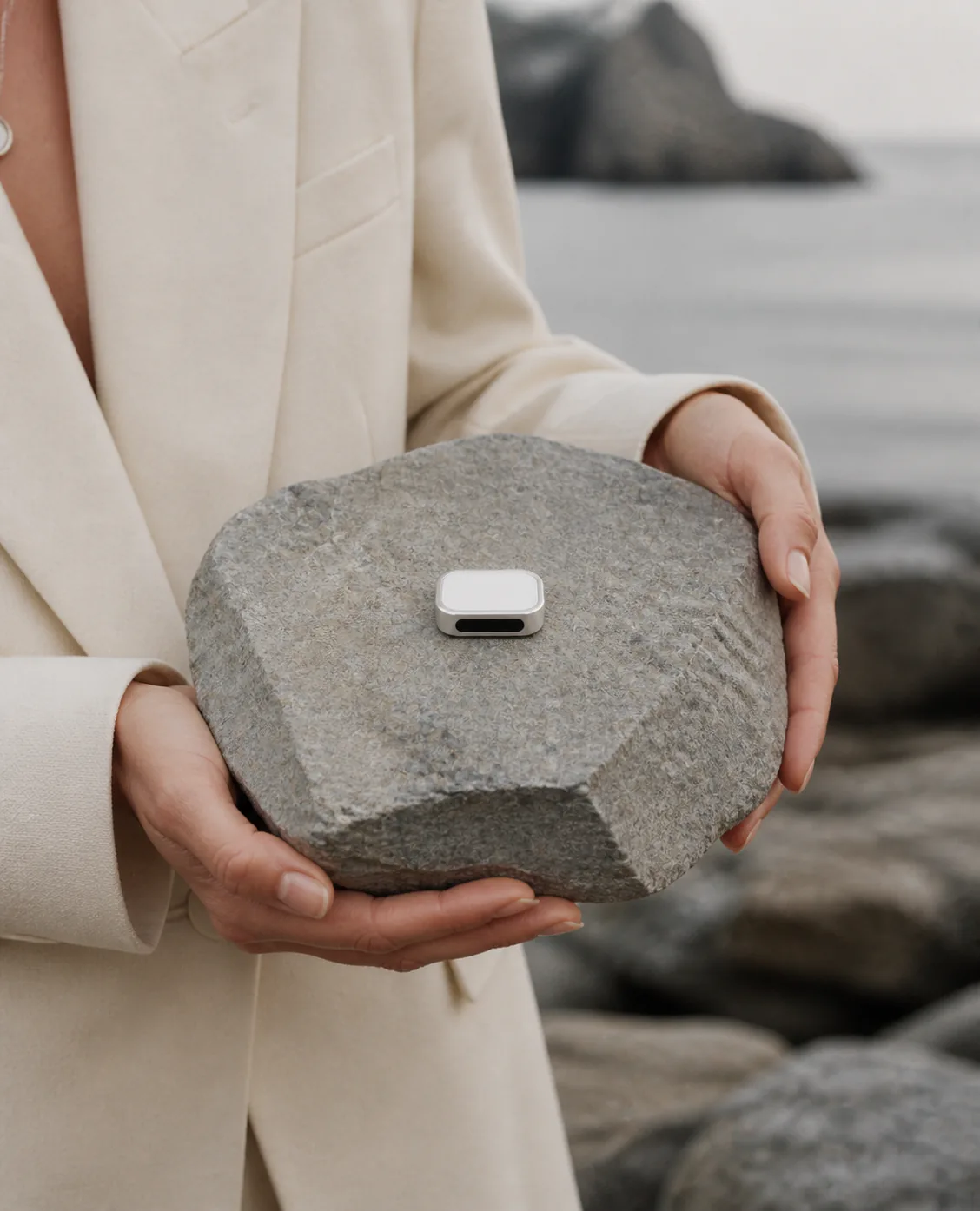 Two hands presenting Presence Key on a carved grey stone
